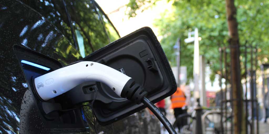 coche híbrido recargando batería en la calle