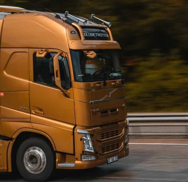 Un camión en naranja que puede tener el sistema vigia, circulando por una carretera