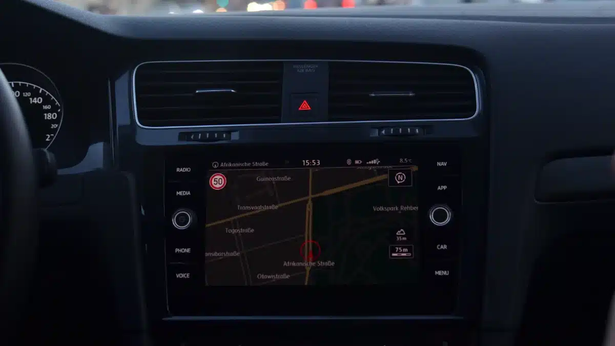 Pantalla de navegación GPS en el salpicadero de un coche mostrando una señal de límite de velocidad