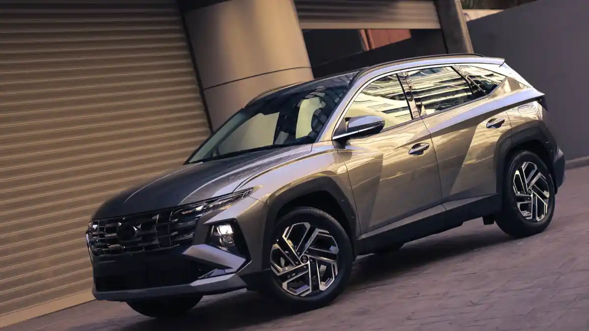 Un SUV Hyundai Tucson gris metalizado estacionado frente a un edificio urbano moderno, resaltando su diseño angular.