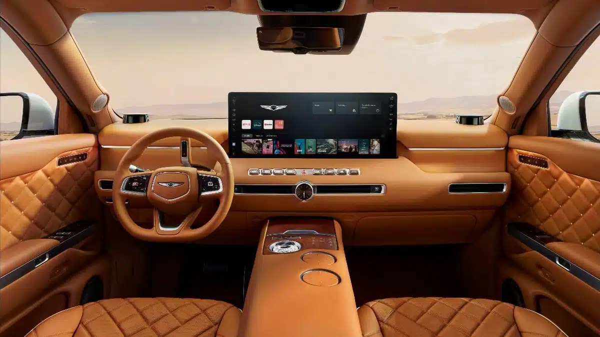 Salpicadero e interior delantero del Genesis GV90 en cuero cognac, con pantalla integrada y volante Genesis