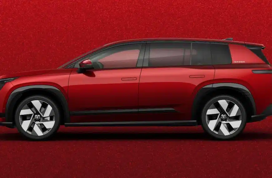 Skoda Peaq visto de perfil sobre fondo rojo en un decorado de estudio