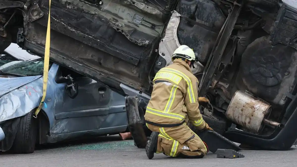 Coche siniestrado con un profesional inspeccionándolo
