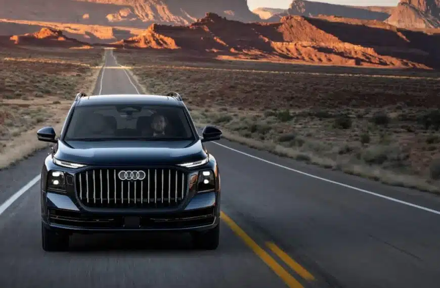 Audi Q9 circulando por una carretera desértica al atardecer
