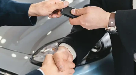 Dos personas llegando a un acuerdo entregando las llaves de un coche de renting o alquiler a largo plazo