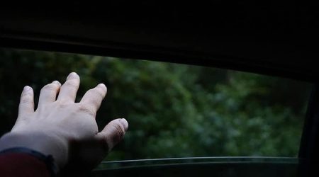 Multa por sacar el brazo por la ventanilla puede ser posible. En la foto aparece una mano saliendo por la ventanilla de un coche